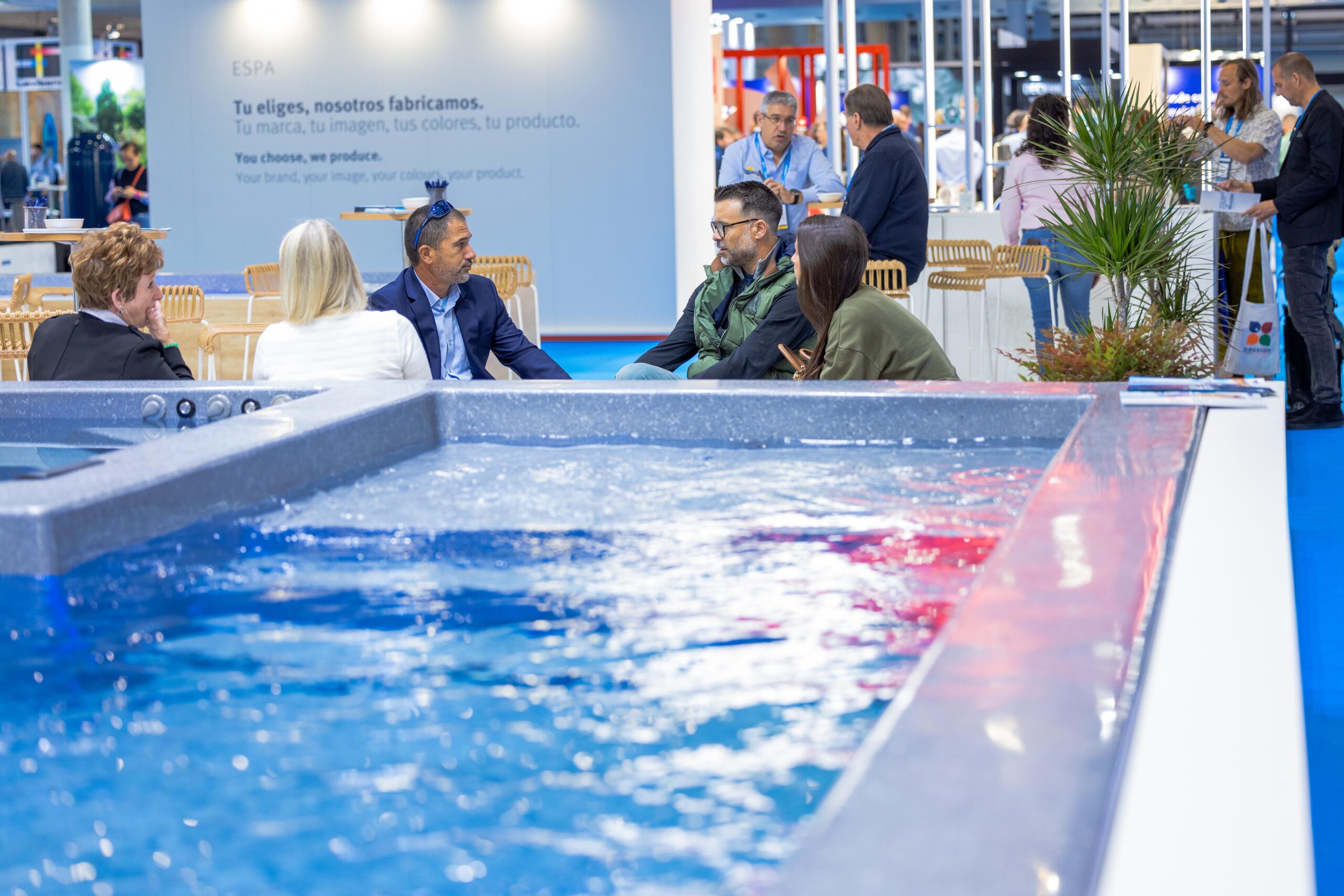 Una piscina en primer plano y al fondo una reunión de negocio en la pasada edición de Piscina Barcelona celebrada en 2023