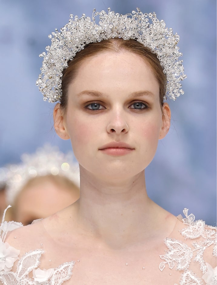 Modelo luciendo un vestido de novia blanco con un tocado elegante