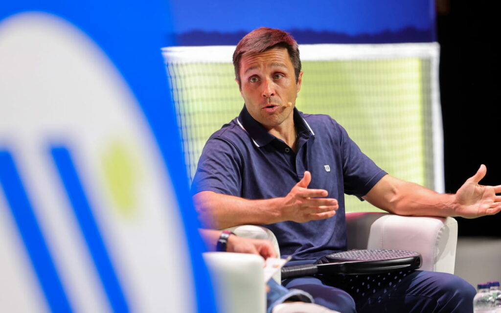 Padel conference speaker onstage discussing industry topics during a professional event session.