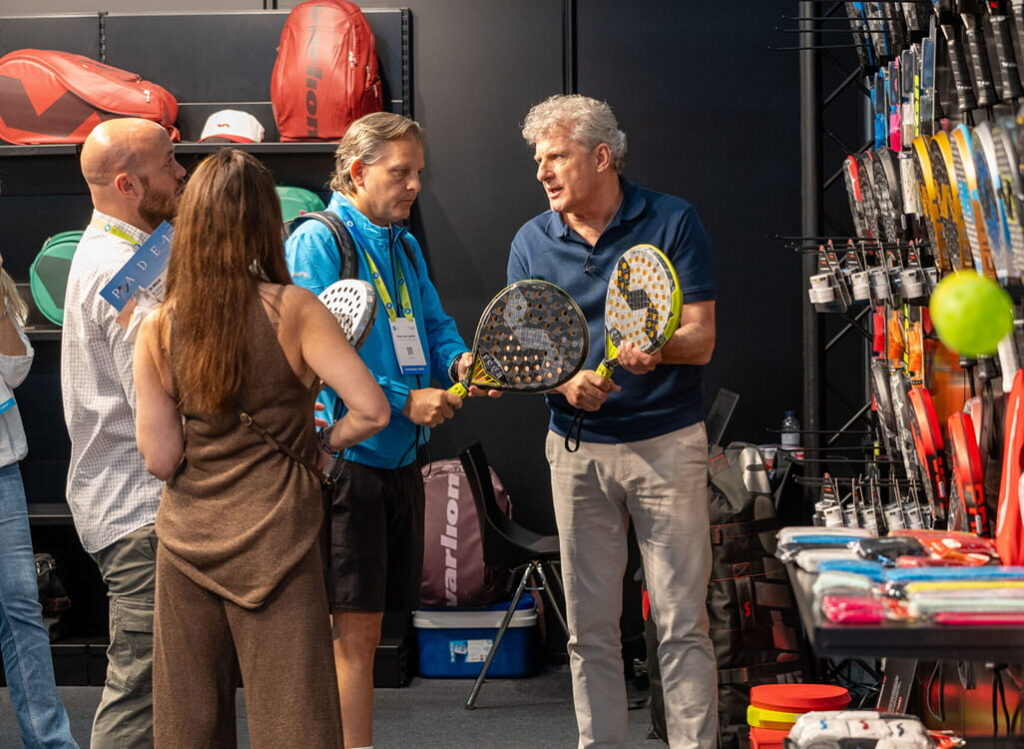 Grupo de personas probando productos de la zona expositiva del salón Padel World Summit.