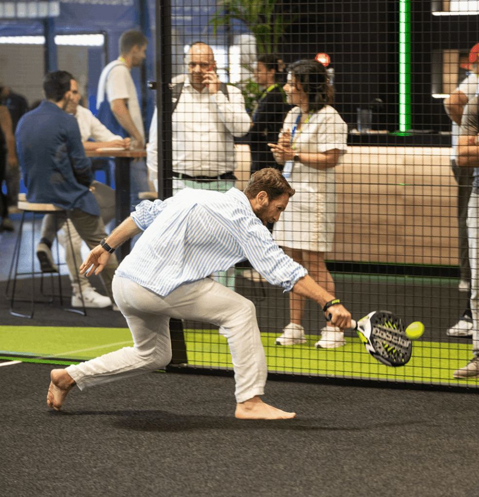 Hombre jugando al padel en una pista de la zona exposita del salón Padel World Summit.