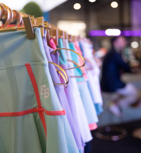 Conjunto de faldas colgadas en un rack, mostrando variedad en la zona expositiva del salón Padel World Summit.