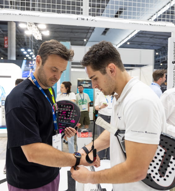 Dos hombres probando un artículo tecnológico relacionado con deportes.