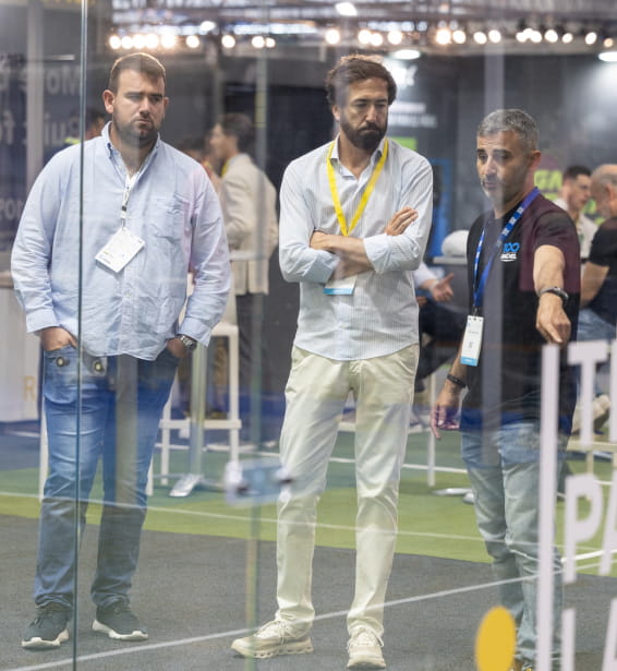 Grupo de hombres de pie frente a una pista de padel.