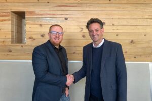 Two men shaking hands and smiling at the camera