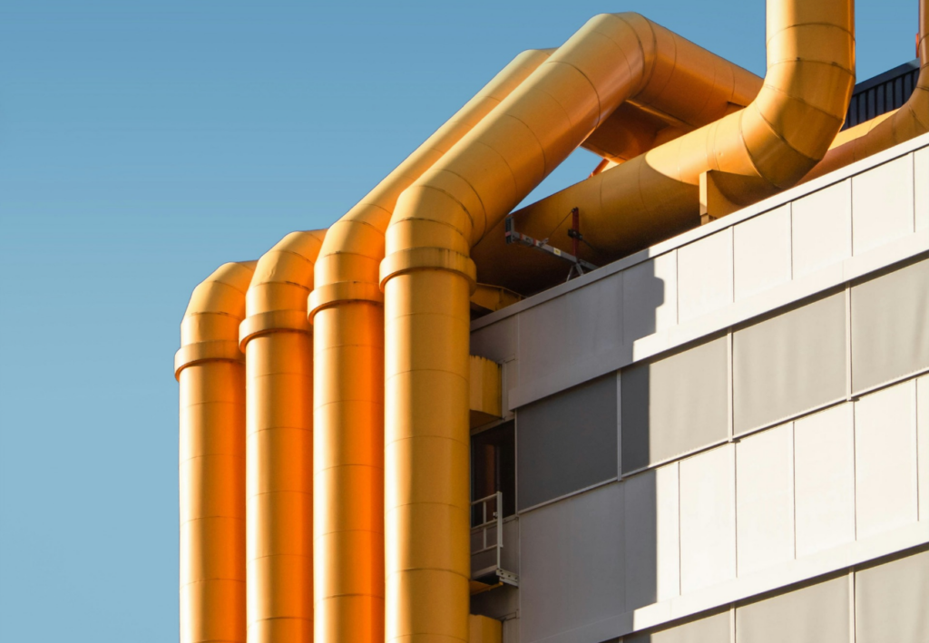 Large yellow pipes outside a factory.