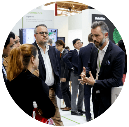 An exhibitor talking to visitors in the exhibition area