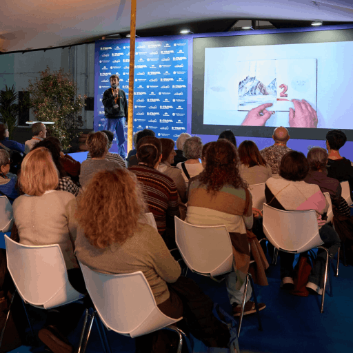 Hombre presentando a un grupo de visitantes en el salón de B-Travel